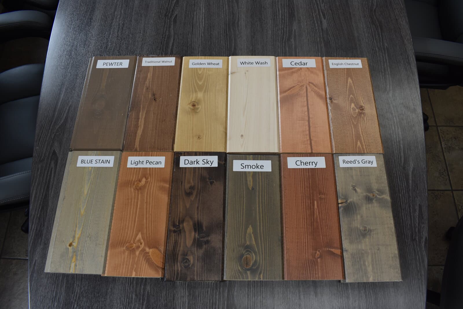Twelve labeled Woodco stain standards including Pewter, Traditional Walnut, Golden Wheat, White Wash, Cedar, English Chestnut, Blue Stain, Light Pecan, Dark Sky, Smoke, Cherry, and Reed's Gray